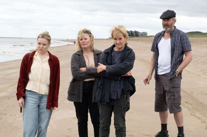 483139,Sherwood - Series 2 Christine Bottomley as Rachel Crossley, Monica Dolan as Ann Branson, Lorraine Ashbourne as Daphne Sparrow and Stephen Dillane as Roy Branson in Sherwood season 2 standing on a beach and looking out with stressed looks on their faces.