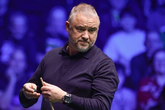 Stephen Hendry chalking the cue.