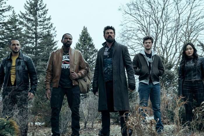 Tomer Capone as Frenchie, Laz Alonso as Mother's Milk, Karl Urban as Billy Butcher, Jack Quaid as Hughie Campbell and Karen Fukuhara as Kimiko in The Boys, stood together in a line outside, with trees behind them.