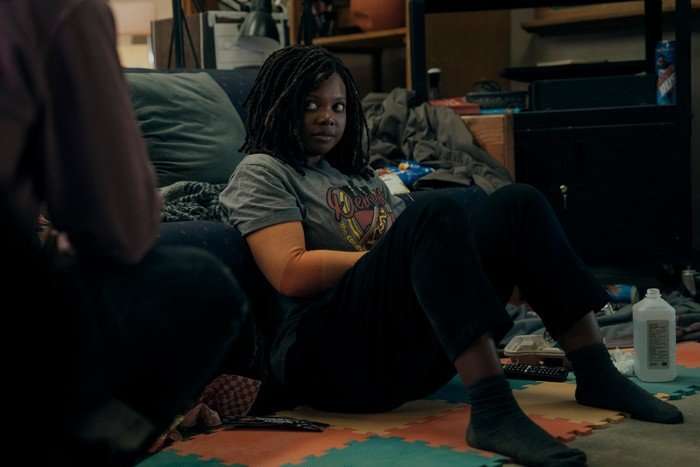 Susan Heyward as Sister Sage in The Boys, sat on the floor, wearing a t-shirt and trousers.