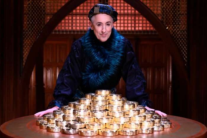 The Traitors - Season 3 Alan Cumming stood over a stack of gold coins.