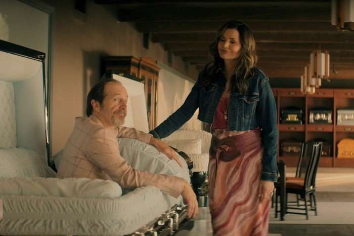 Denis O’Hare as Wally, Geena Davis as Renee in The Boroughs Denis O’Hare as Wally, Geena Davis as Renee in The Boroughs. Wally is sitting up in a coffin, while Renee, standing, looks down at him, with a hand placed on it.