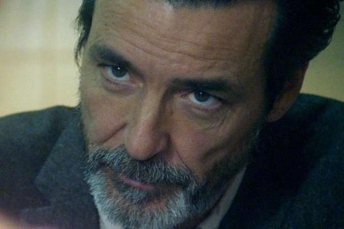 Under Suspicion: Kate McCann (wt) Hugo Nicolau as João Carlos in Under Suspicion: Kate McCann sitting across the table, staring intently at someone.
