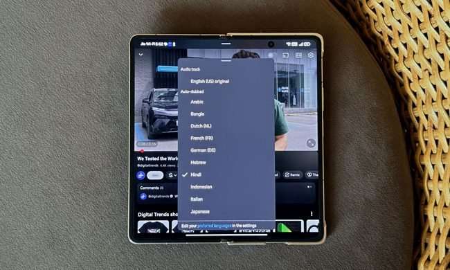 YouTube app with audio track settings on an Honor Magic V6 placed on a sofa.