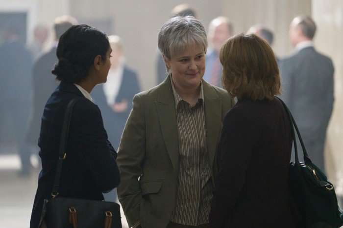 Philippa Dunne facing Aim&eacute;e-Ffion Edwards and Aasiya Shah while standing in a crowded hallway in a courthouse.