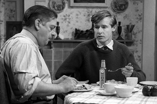 A young Ken Barlow, c. 1960, sat eating around a dinner table with his dad Frank in a scene from Coronation Street