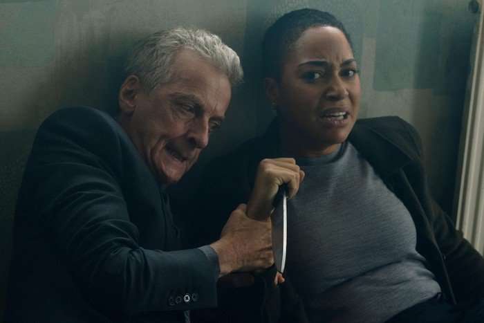 criminal-record-cush-jumbo Cush Jumbo and Peter Capaldi sat down next to each other with looks of anguish. Jumbo is holding a knife and looks scared while Capaldi his holding her hand