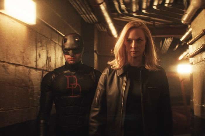 Daredevil and Karen Page walk down a dark underground tunnel with stony expressions on their faces