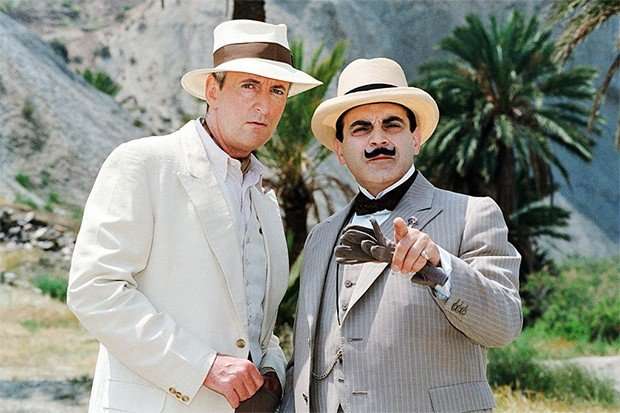 David Suchet as Hercule Poirot David Suchet as Hercule Poirot standing next to Hugh Fraser as Captain Hastings in linen suits looking into the camera.