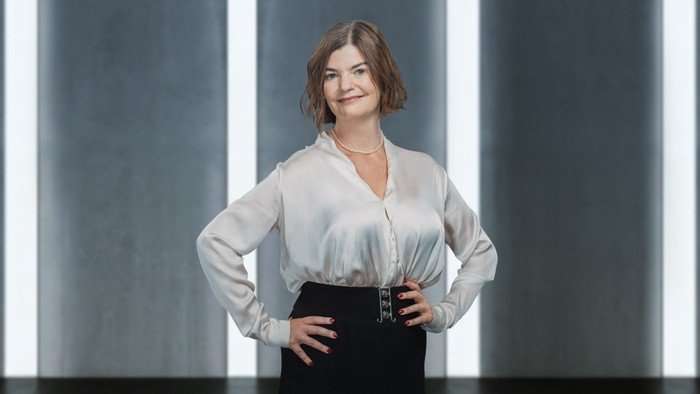 Melissa stood with her hands on her hips, wearing a satin blouse and black pencil skirt.