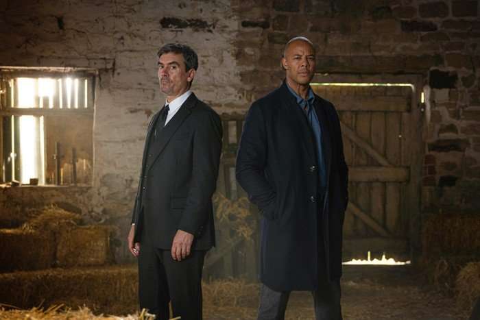 Cain and Michael stood back to back in a barn
