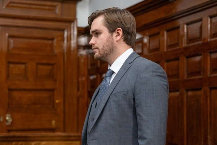 James Chase as Tom King in a suit in court in Emmerdale