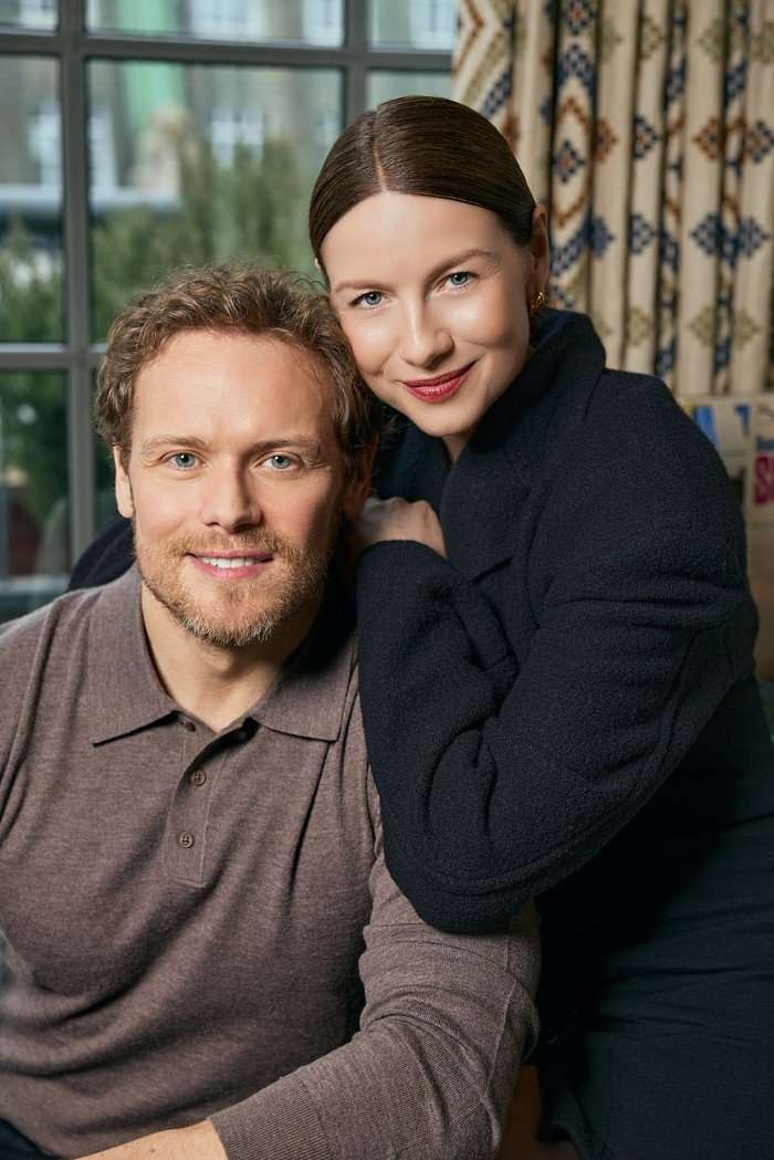 Sam Heughan and Caitr&iacute;ona Balfe smiling and posing next to each other.
