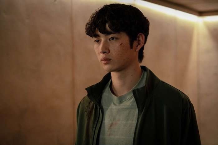 Sean Kaufman stars in For All Mankind season 5; in this scene, Alex looks upset while standing in a corridor, with a small cut on his right cheek
