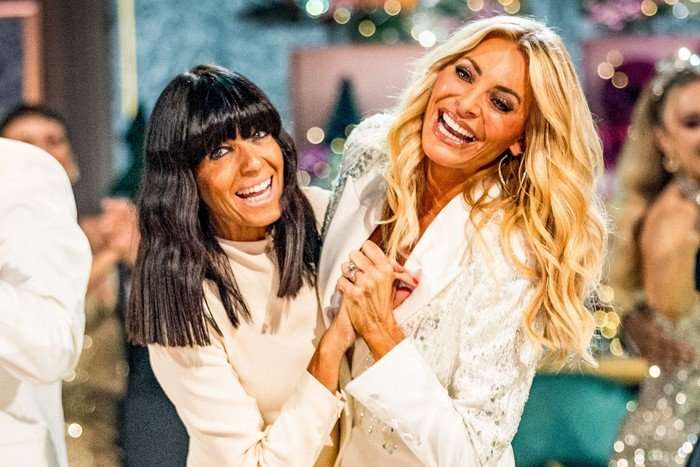 Claudia Winkleman and Tess Daly stood next to each other holding hands in a dancers pose.