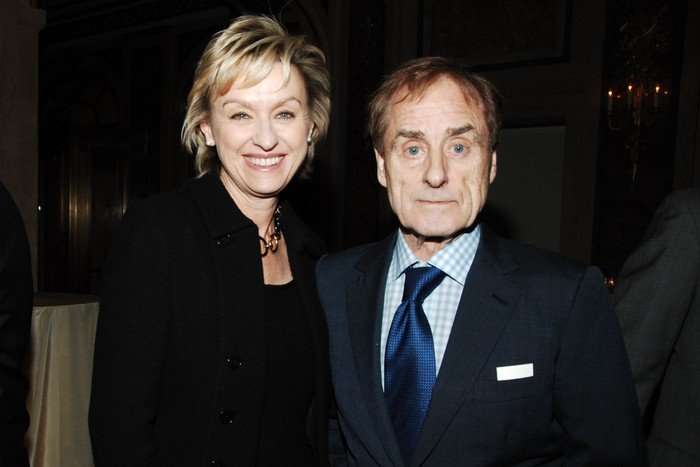 Tina Brown and Harry Evans standing outside on a pavement in New York City, wearing formal attire and smiling.
