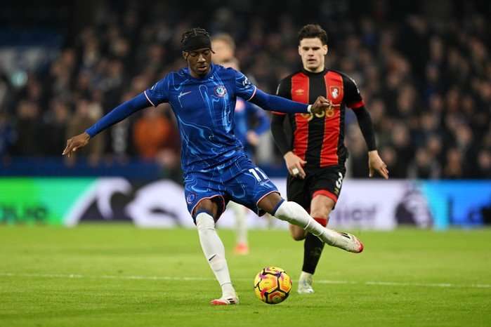 Noni Madueke of Chelsea shoots under pressure from Milos Kerkez of AFC Bournemouth during the Premier League match between Chelsea FC and AFC Bournemouth at Stamford Bridge on January 14, 2025 in London, England.