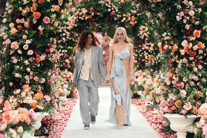 Zendaya as Rue Bennett (left) and Hunter Schafer as Jules Vaughn walk down an aisle in Euphoria season 3.