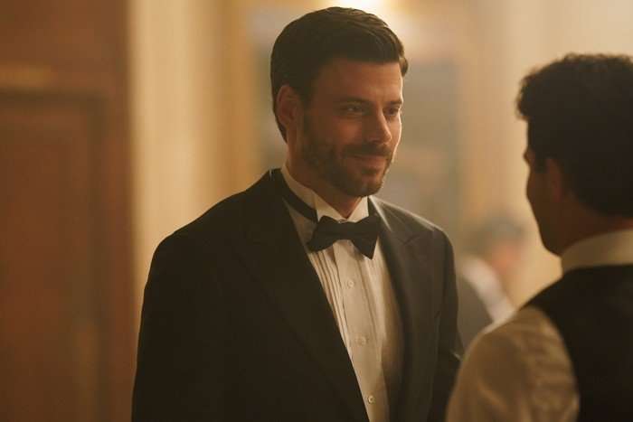 Heated Rivalry François Arnaud as Scott Hunter in Heated Rivalry; he is seen here in a tuxedo, smiling at somebody stood in front of him