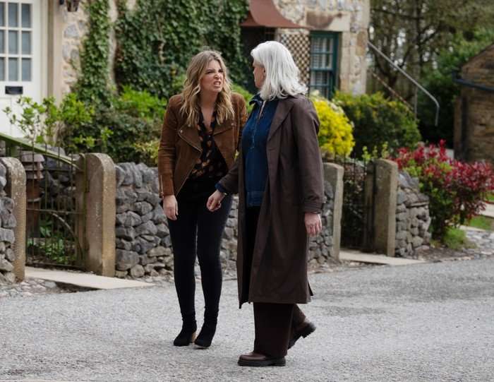 Charity and Dr Todd walking through the street in Emmerdale