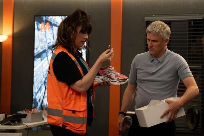 Caleb and Kerry are startled by a label in a scene from Emmerdale
