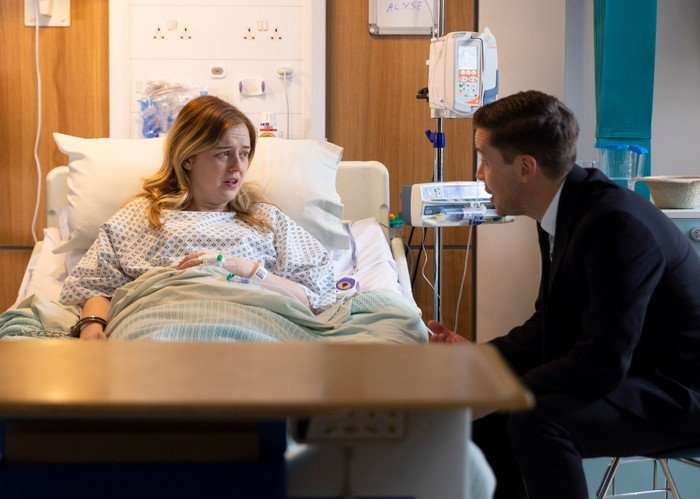 Todd sits beside Summer, who is lay in a hospital bed, in a scene from Coronation Street