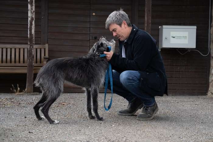 Cain looks into Monty the dog's eyes in Emmerdale