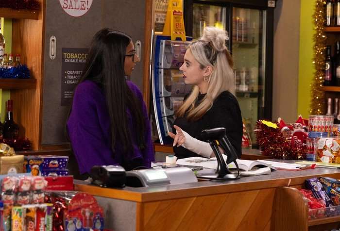 Nina and Asha stood behind the corner shop counter in Coronation Street