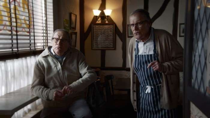 Two versions of Roy Cropper stand in his cafe in Coronation Street - one real, and one a figment of Sam's imagination.