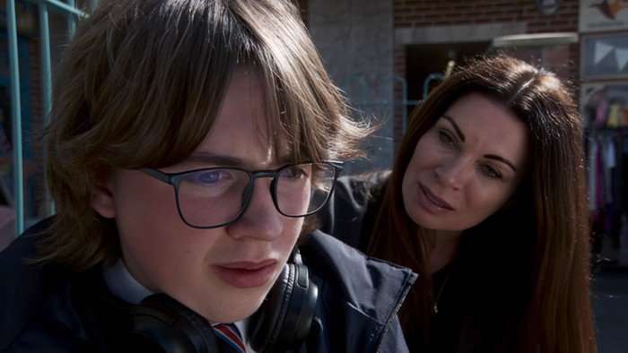 Carla peers over Sam's shoulder in Coronation Street