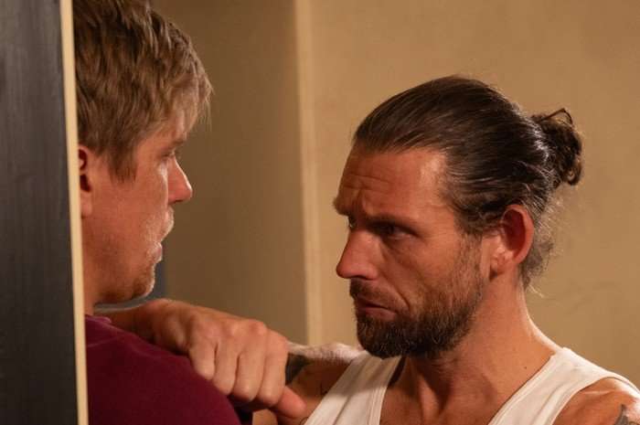 Kev holds Robert against a wall in prison in Emmerdale