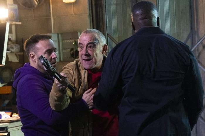 15_06_coro_garage_03 Ronnie and Tyrone hold Kevin back, who is holding a wrench, in a scene from Coronation Street