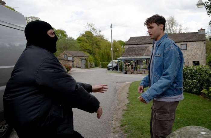 19_06_emm_lewis_02 A masked man approaches Lewis in Emmerdale