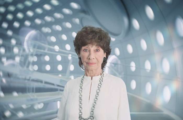 523299,TITLE:Doctor Who S2 Carole Ann Ford as Susan Foreman in a white outfit and silver necklace staring at the camera and standing inside the TARDIS in Doctor Who: The Interstellar Song Contest.