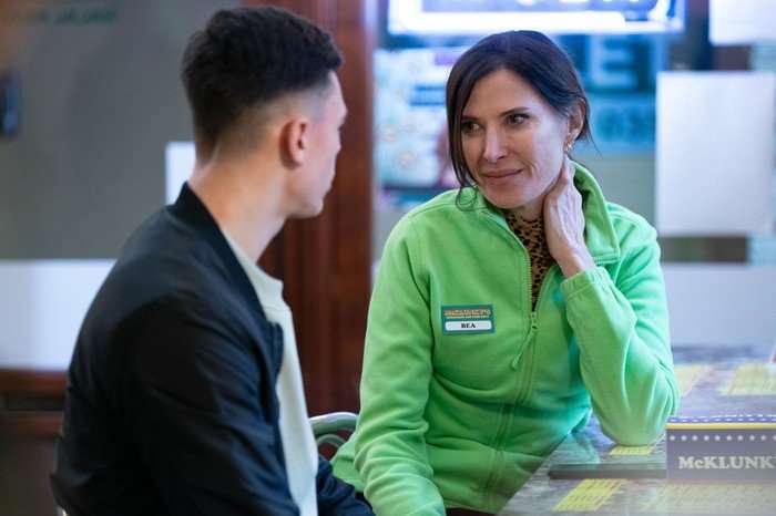 553646,TITLE:Eastenders Bea, wearing a green McKlunky's uniform, chats to Will in the takeaway in EastEnders