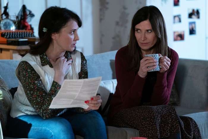 559297,TITLE:Eastenders Bea sits beside Honey, who is reading a letter in EastEnders