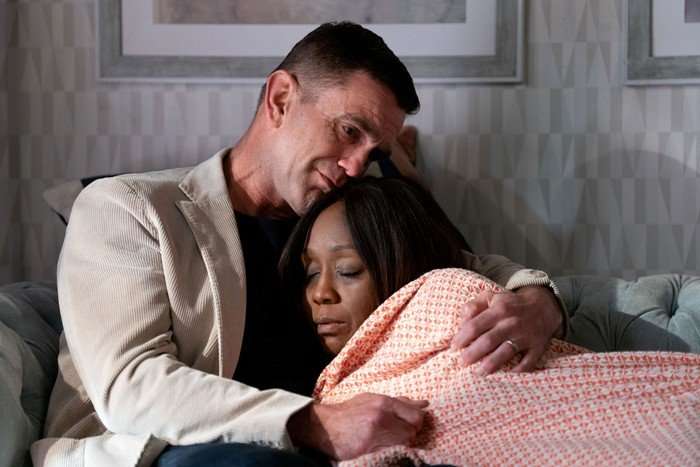 Diane Parish as Denise Fox lying under a blanket in the arms of Scott Maslen as Jack Branning in EastEnders.