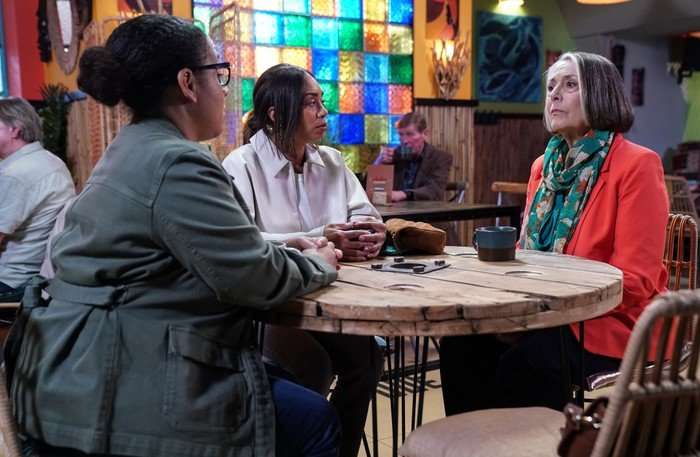Libby and Chelsea chat to Sheila across a table in Knight Fusion in a scene from EastEnders