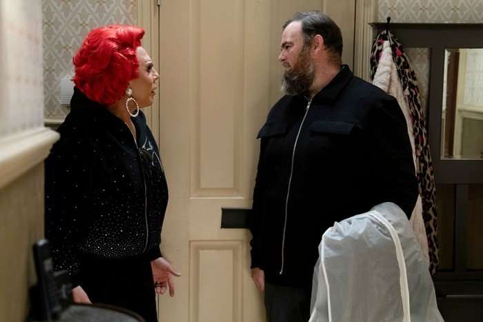 566251,TITLE:Eastenders La Voix talks to a man in the Queen Victoria hallway in EastEnders