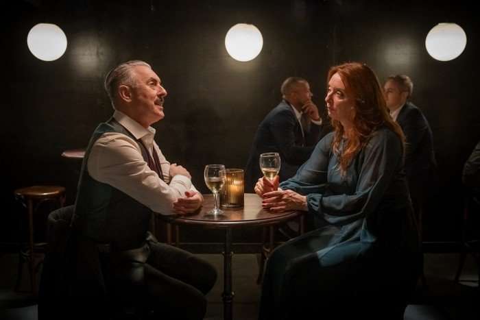 Tip Toe - Ep5 Leo and Steph share a glass of wine at a dimly lit bar, sat around a small table