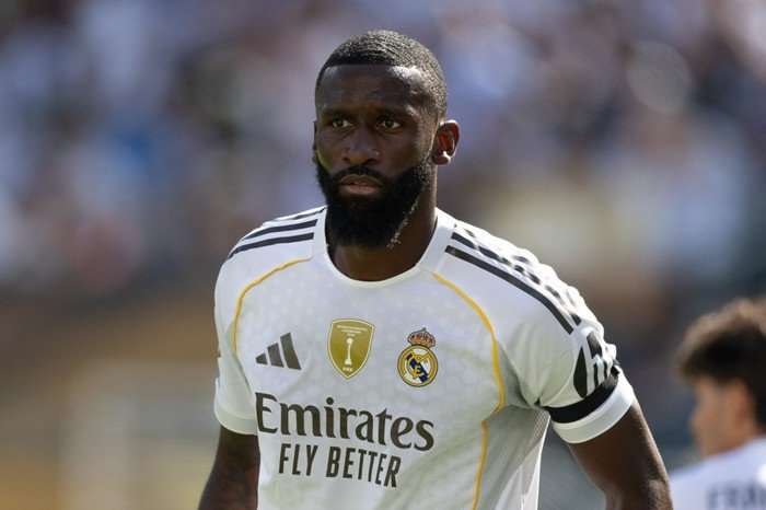 Antonio Rudiger Antonio Rudiger, in white and gold Real Madrid football kit, stands watching play.