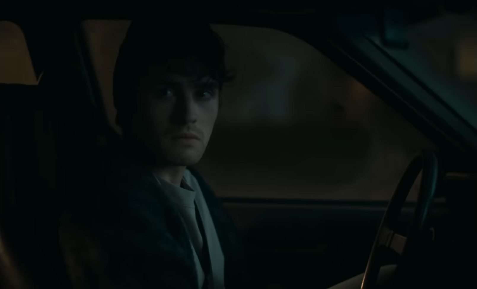 Bear (Michael Johnston) sitting in a car in the horror film, Obsession.