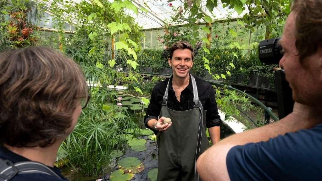 Behind-the-scenes as Antoni Porowski helps to feed the Giant waterlily at Kew Gardens near London, UK, as seen in National Geographic’s Best of the World with Antoni Porowski. (National Geographic/John Wendle)