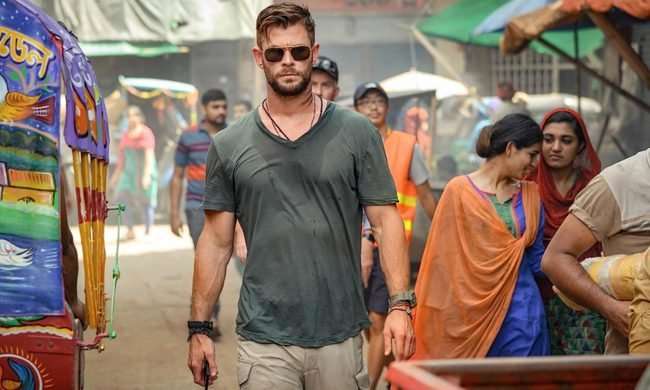 Tyler Rake walks toward the camera in Extraction.