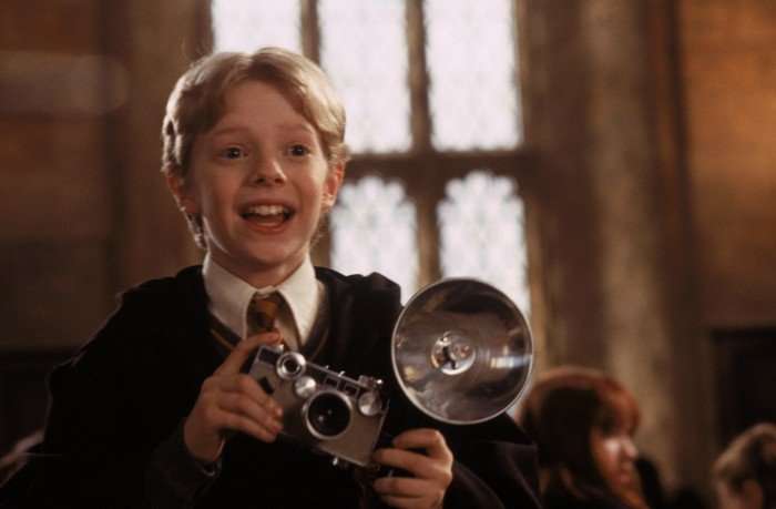 Hugh Mitchell as Colin Creevey in Harry Potter Hugh Mitchell as Colin Creevey in Harry Potter. He's wearing a Gryffindor uniform and is holding a camera.