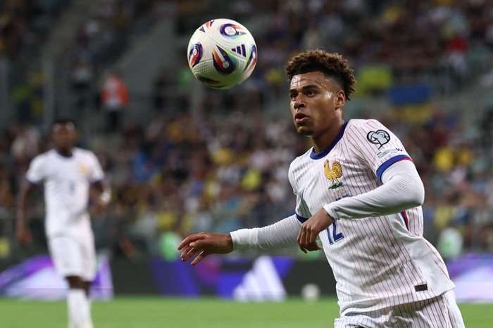 D&eacute;sir&eacute; Dou&eacute;, in white and blue France football kit, watches the bouncing ball.