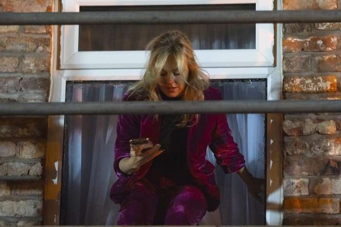 Sarah, stood on some scaffolding, uses her phone in a scene from Coronation Street