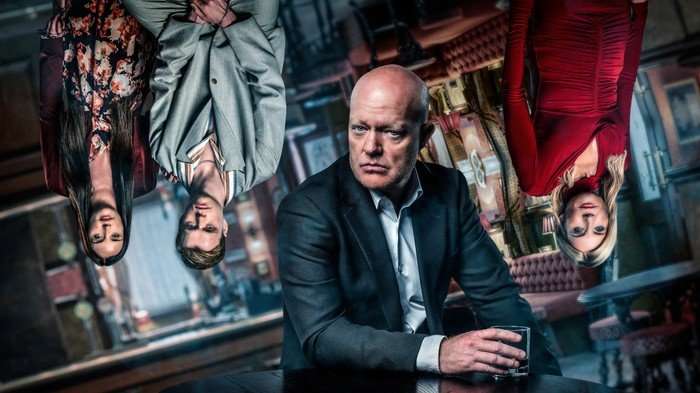 EastEnders - The Night That Changes Everything with Max Branning sat down and Lauren Beale, Oscar Branning and Cindy Beale standing up but stylised as upside down.