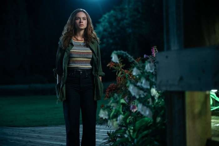 Sadie Soverall as Percy Fraser standing in the darkness on a garden path, looking shocked.