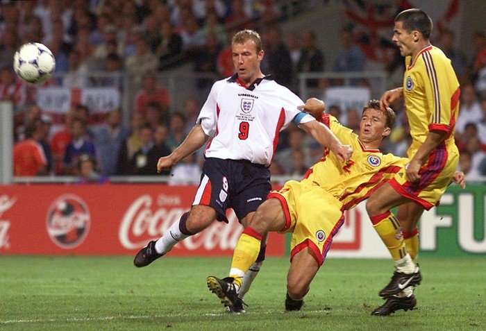 English forward Alan Shearer avoids a tackle by Romanian defender Dan Petrescu at Toulouse Stadium during the 1998 World Cup group G match between England and Romania.